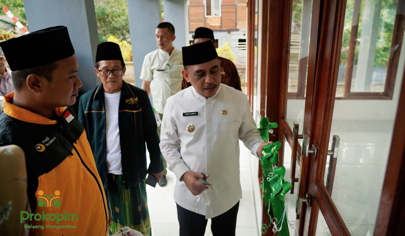 Bupati Yusra Alhabsyi melakukan meresmikan dan pengguntingan pita Mesjid Darul Istiqomah Desa Pomoman, Kecamatan Poigar. (Photto Bagian Protokoler Pemkab Bolmong)